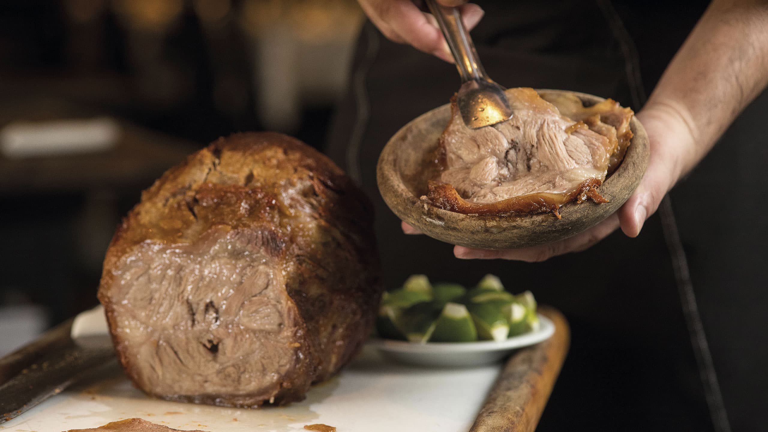 Cupim assado sendo servido na cumbuca de madeira
